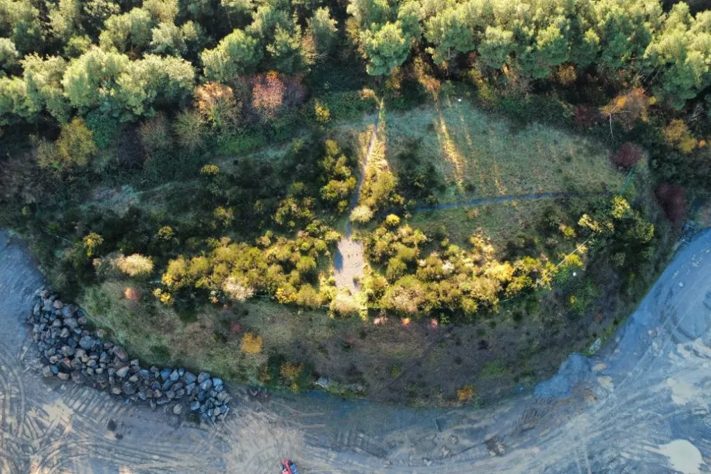 Vue aérienne d’une carrière Nexstone en cours de réhabilitation avec zones végétalisées, fronts rocheux et continuité écologique à Trégueux
