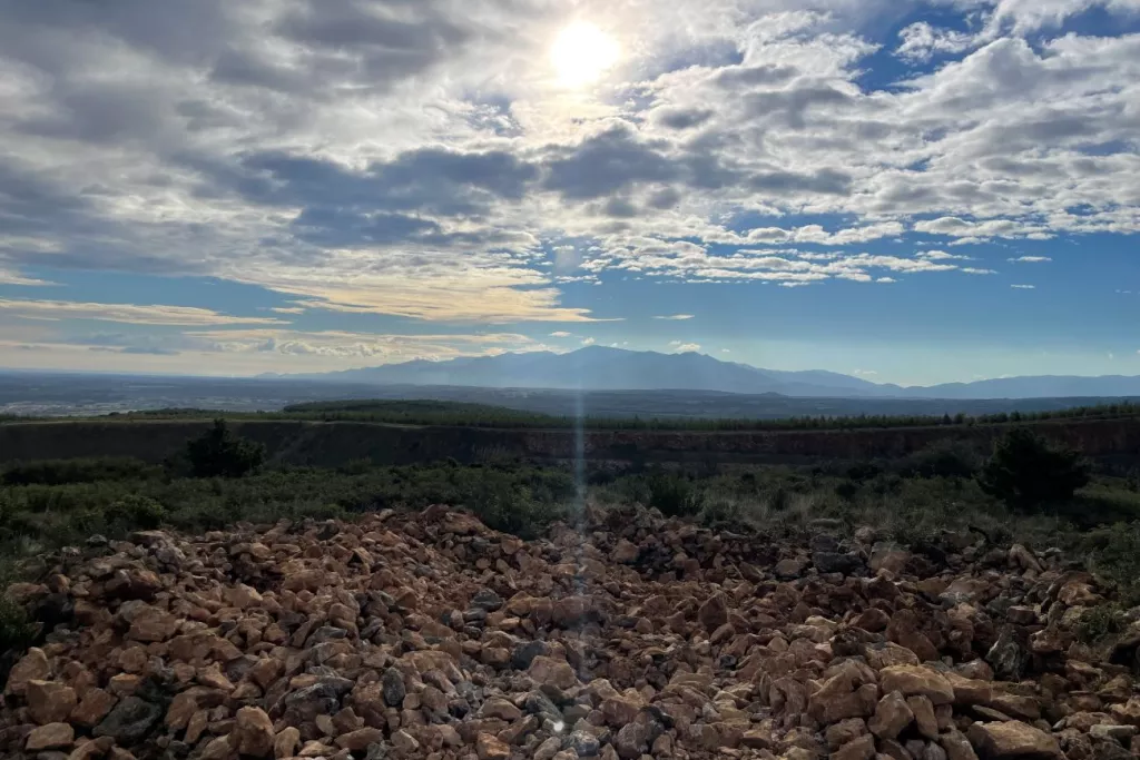 Carrière de granulats avec paysage naturel et reliefs montagneux à l’horizon, illustrant l’intégration de la biodiversité dans les sites d’exploitation minérale
