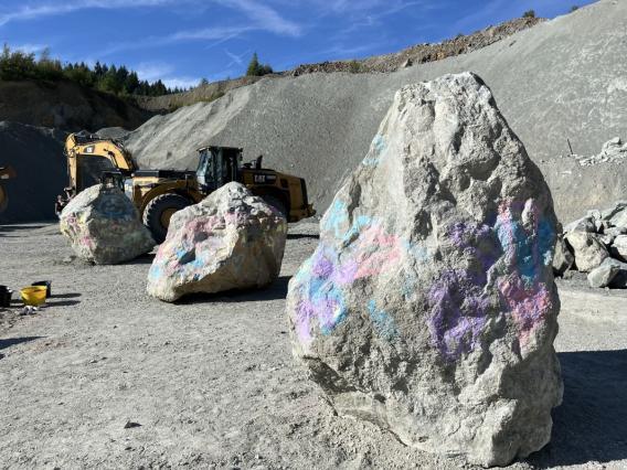 Blocs rocheux en carrière avec engins de chargement pour extraction et production de granulats