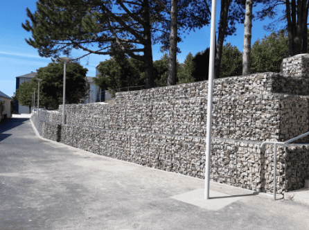 Aménagement urbain avec mur en gabions, structure en pierres pour stabilisation des sols et intégration paysagère