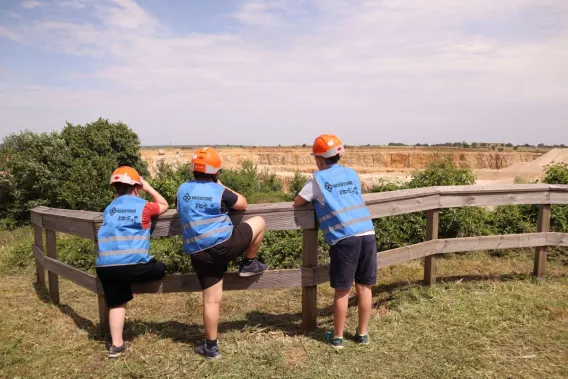 Élèves observant la carrière de Bainville depuis un belvédère lors d'une visite pédagogique consacrée à l'exploitation du site et à son environnement.