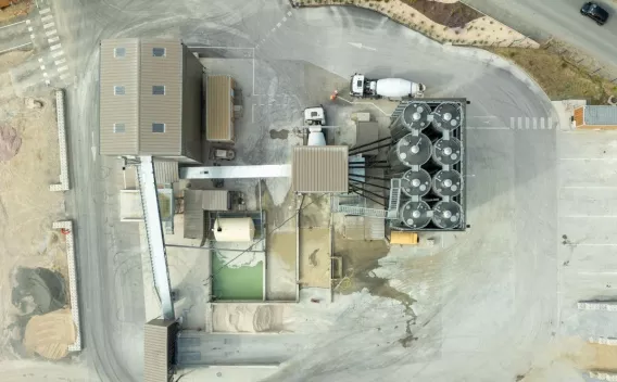 Centrale à béton de Cuxac-d’Aude, vue aérienne du site de production avec silos de stockage, zones de chargement et circulation de camions toupies.