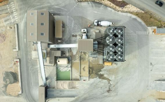 Centrale à béton de Cuxac-d’Aude, vue aérienne du site de production avec silos de stockage, zones de chargement et circulation de camions toupies.