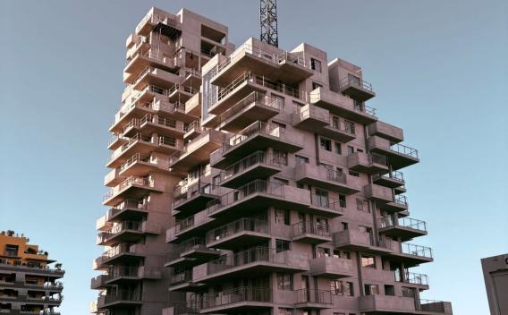 Immeuble résidentiel en construction avec structure béton apparente, illustrant un projet d’aménagement urbain en phase de gros œuvre.
