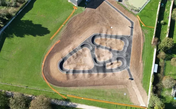 Vue aérienne d’un pumptrack avec revêtement en enrobé pour aménagement sportif et de loisirs.