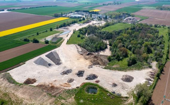 Plateforme Valormat de Bischoffsheim, site de valorisation de matériaux minéraux avec zones de stockage en tas, circulation d’engins et intégration dans un environnement agricole.