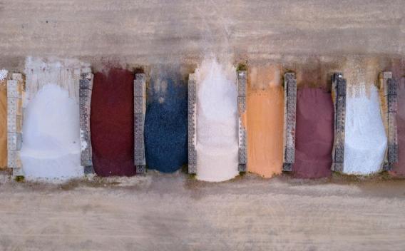 Plateforme Valormat de Layrac, zone de stockage et de valorisation de matériaux minéraux avec différents granulats triés par couleur, illustrant la diversité des produits disponibles pour l’aménagement et la construction.