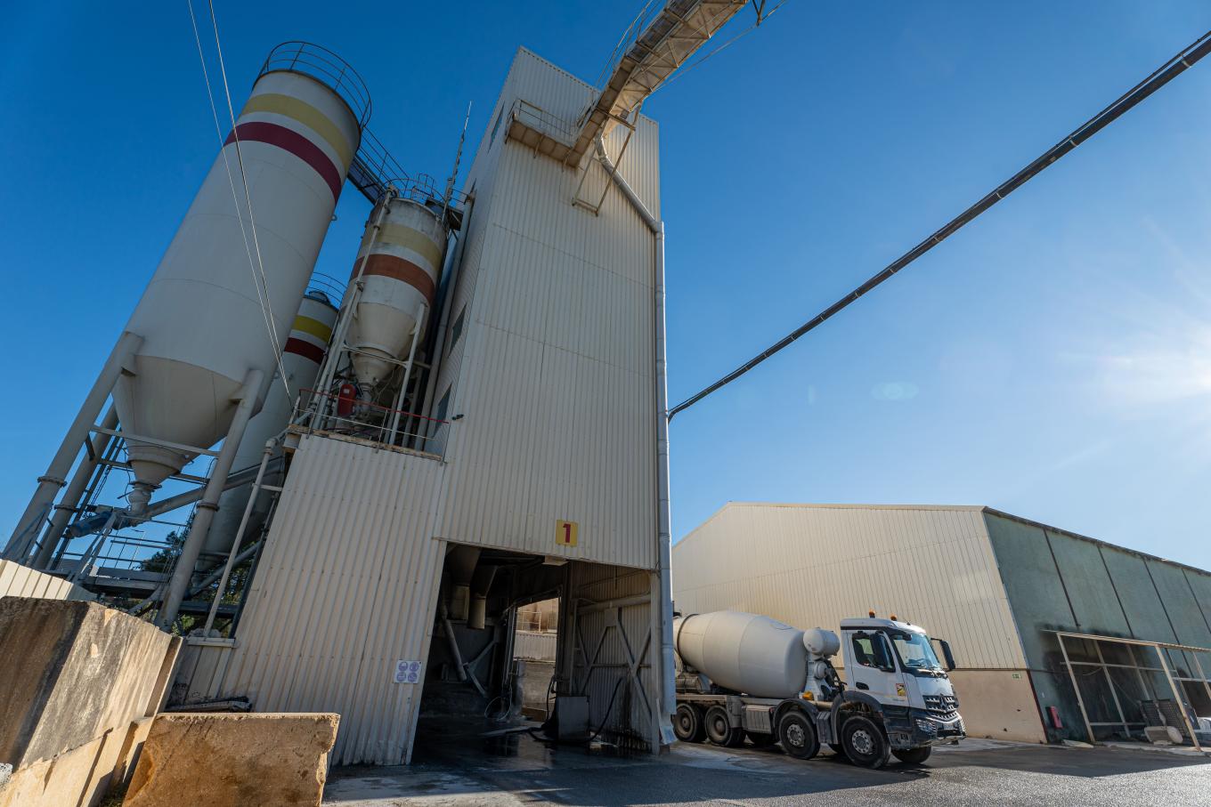 Centrale à béton de Vendargues avec silos de stockage et installation de production, camion toupie en cours de chargement sur un site.