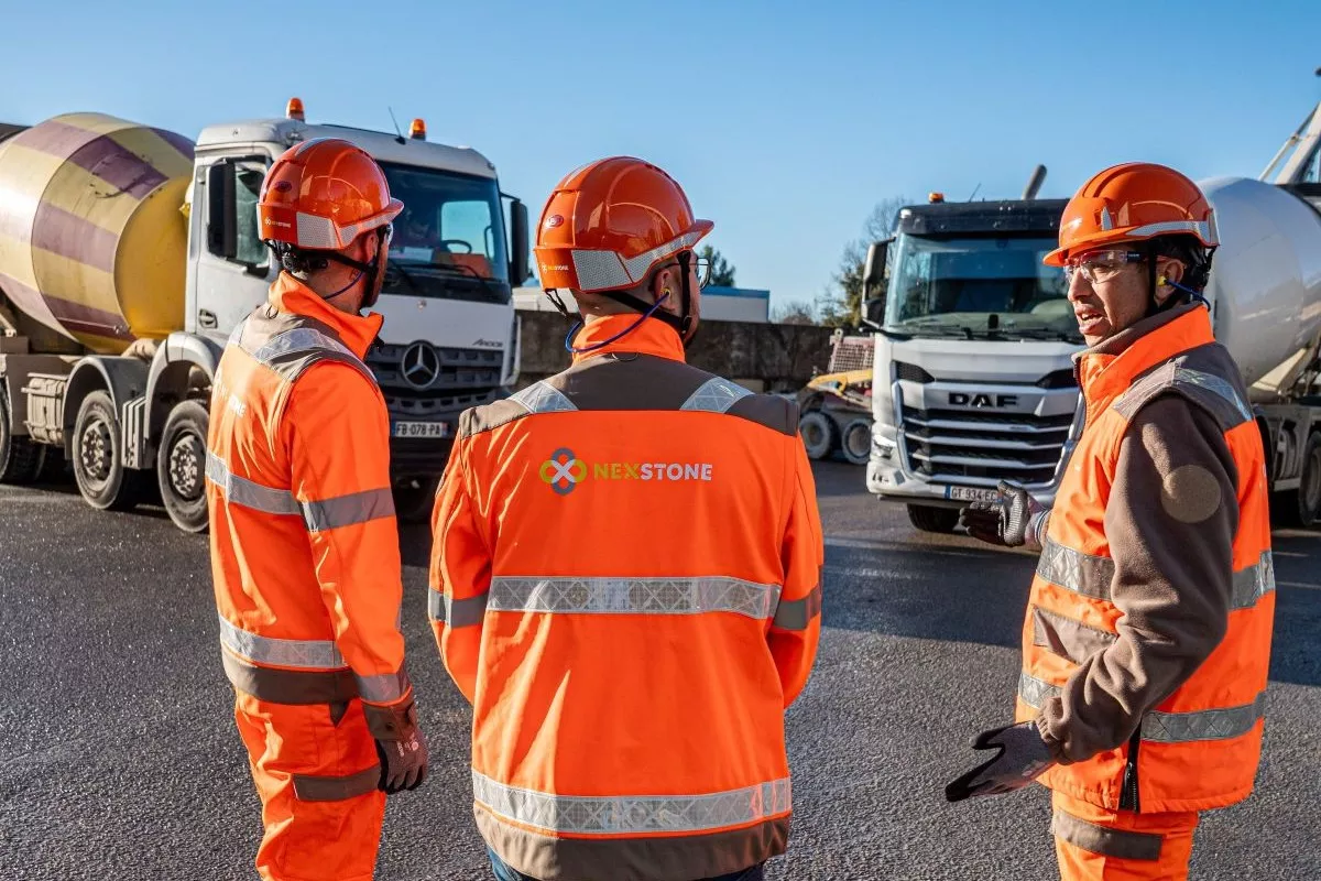 Centrale à béton Nexstone avec équipe de production et camions de transport du béton.