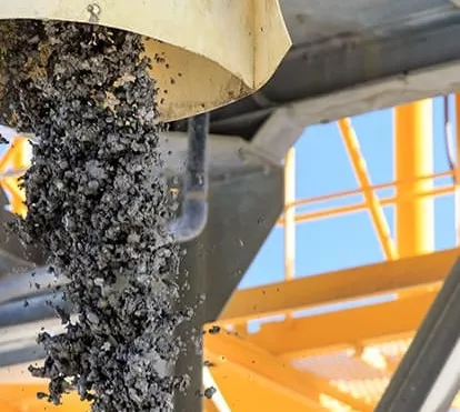 Granulats déversés sur site industriel pour fabrication d’enrobés, matériaux destinés aux travaux routiers.