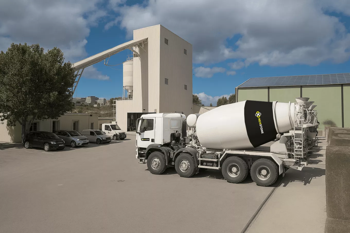 Centrale à béton Nexstone avec camion toupie en chargement sur site de production de matériaux de construction.