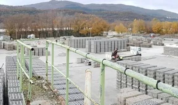 Plateforme industrielle de production de blocs béton avec stockage de produits préfabriqués pour la construction et l’aménagement.