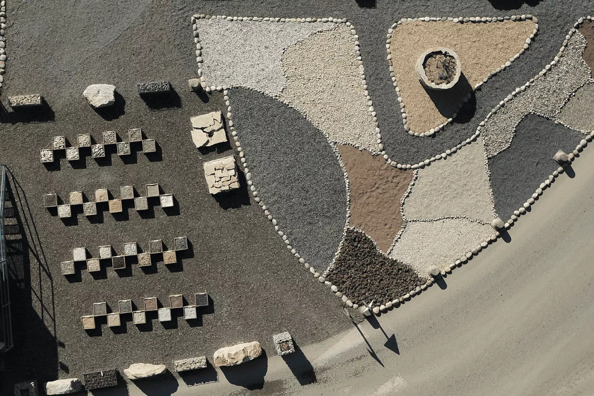 Échantillons de granulats minéraux et matériaux décoratifs présentés sur une plateforme, utilisés pour l’aménagement paysager, les revêtements de sol et les projets d’infrastructure