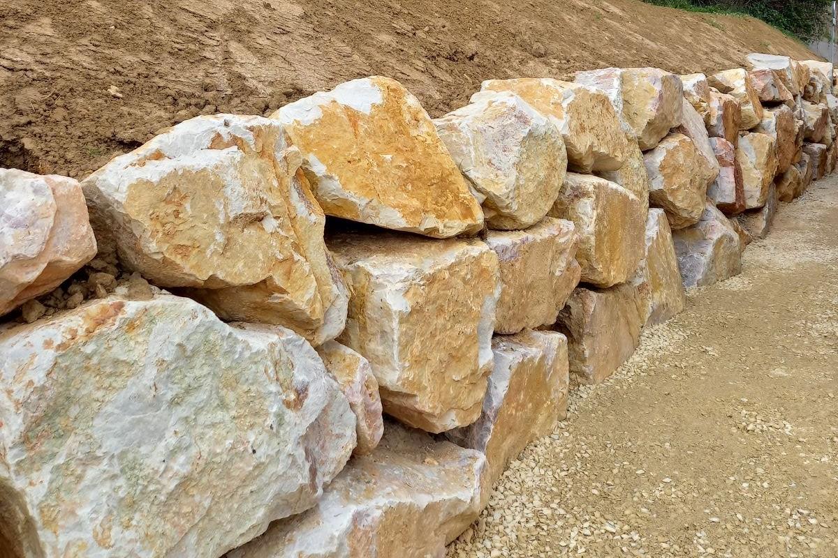 Mur en blocs d’enrochement en pierre naturelle pour soutènement, stabilisation de terrain et aménagement extérieur durable.