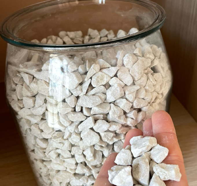 Granulat concassé blanc calibré, utilisé pour les aménagements paysagers, les revêtements décoratifs et les finitions minérales.