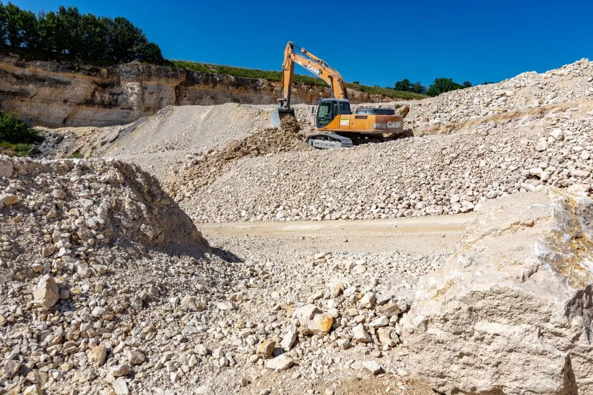 Engin d’extraction sur un stock de granulats calcaires à la carrière Nexstone d’Étalans