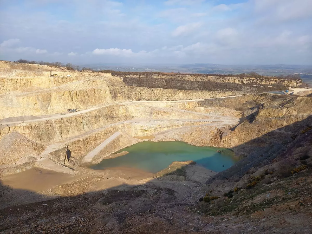 Vue panoramique de la carrière de Doville avec ses fronts d’extraction de grès et son plan d’eau
