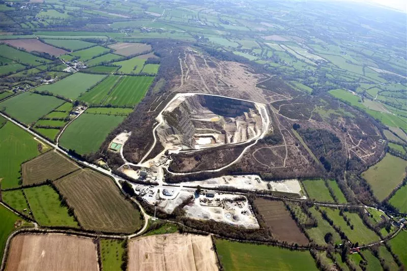 Vue aérienne de la carrière de Sainte-Croix-Hague, avec la zone d’extraction et ses installations, entourée de parcelles agricoles et de paysages bocagers.