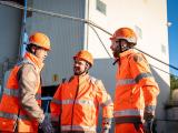 Collaborateurs sur la centrale à béton de Vendargues portant des équipements de protection (casques, tenues haute visibilité) en échange sur site de production, illustrant la coordination des opérations et des équipes.