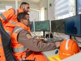 Collaborateurs Nexstone en salle de contrôle supervisant la production de matériaux, avec équipements informatiques et suivi des installations industrielles