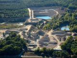 Carrière de Saint-Martin-d’Oney, vue aérienne du site d’extraction de granulats avec zones de stockage, pistes d’exploitation, bassins et intégration dans un environnement boisé.