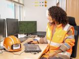 Collaboratrice Nexstone en salle de contrôle supervisant la production de matériaux minéraux sur écrans.