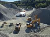 Carrière de Rougemont avec engins de terrassement et stockage de granulats sur site d’extraction.