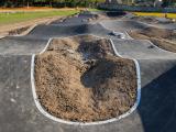 Pumptrack de Romilly en cours d’aménagement avec modelage des reliefs et revêtement en enrobé.