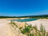 Vue de la gravière d'Osselle dans le Doubs, avec un plan d'eau entouré de bancs de sable, illustrant un site d'extraction de granulats favorable à la biodiversité