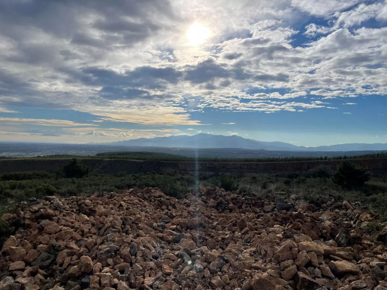 Carrière de granulats avec paysage naturel et reliefs montagneux à l’horizon, illustrant l’intégration de la biodiversité dans les sites d’exploitation minérale